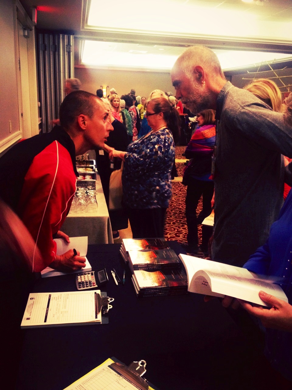 Damo Mitchell speaking with a NQA conference attendee during his book signing